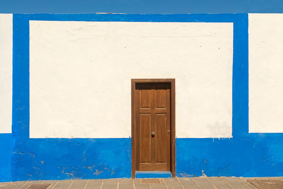 Wooden door set in a blue and white painted wall