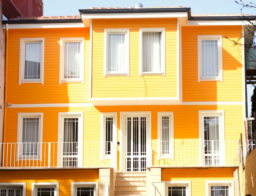 Painted exterior wall with white framed windows and a door