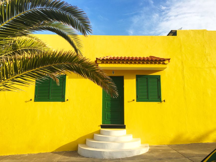 Painted house front with green shutters