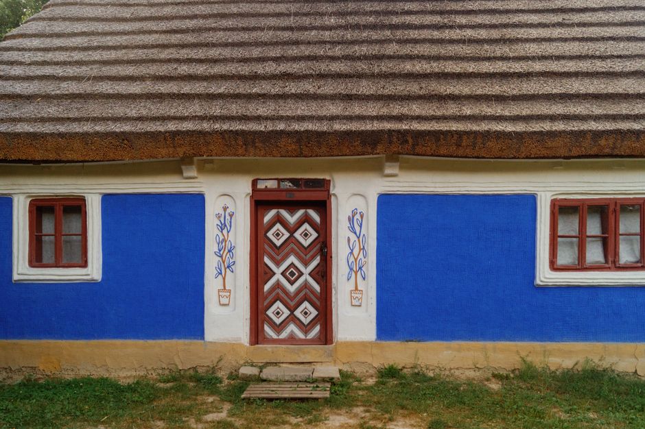 Painted house wall with a small window in daylight