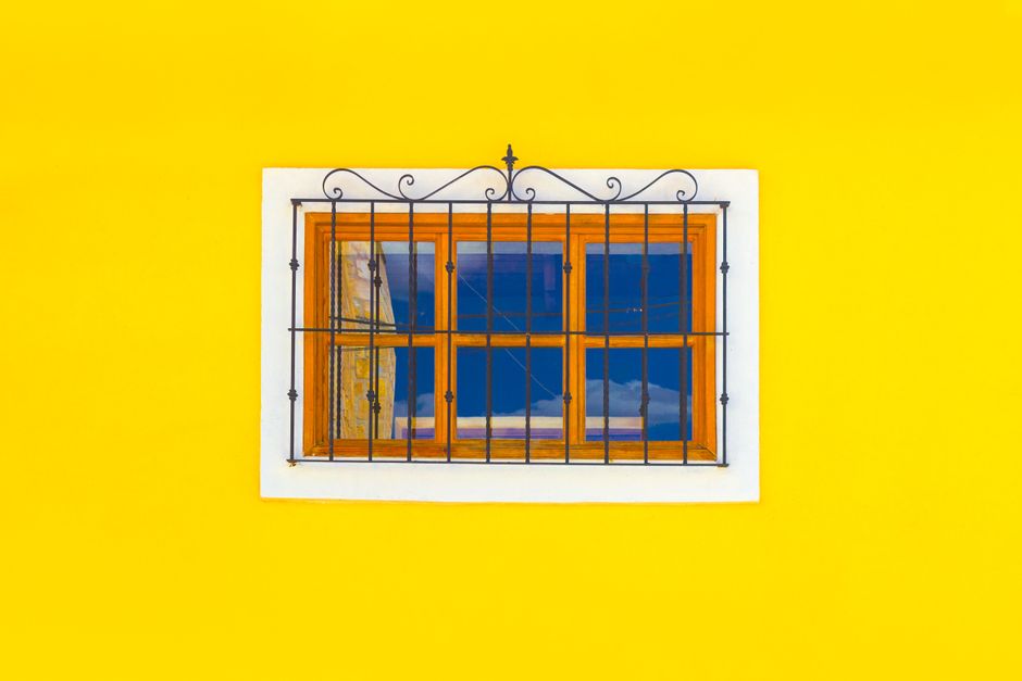 Orange painted house wall with small windows